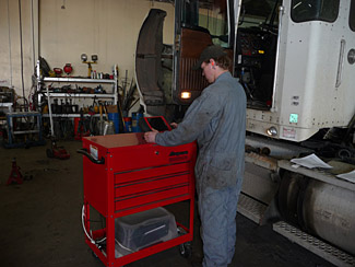 technition diagnosing truck side view